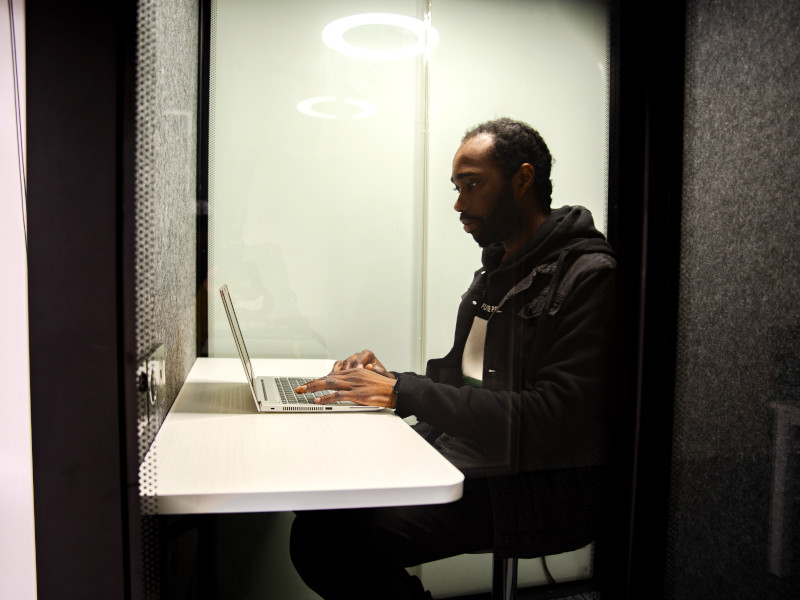 Man working in private booth on his laptop