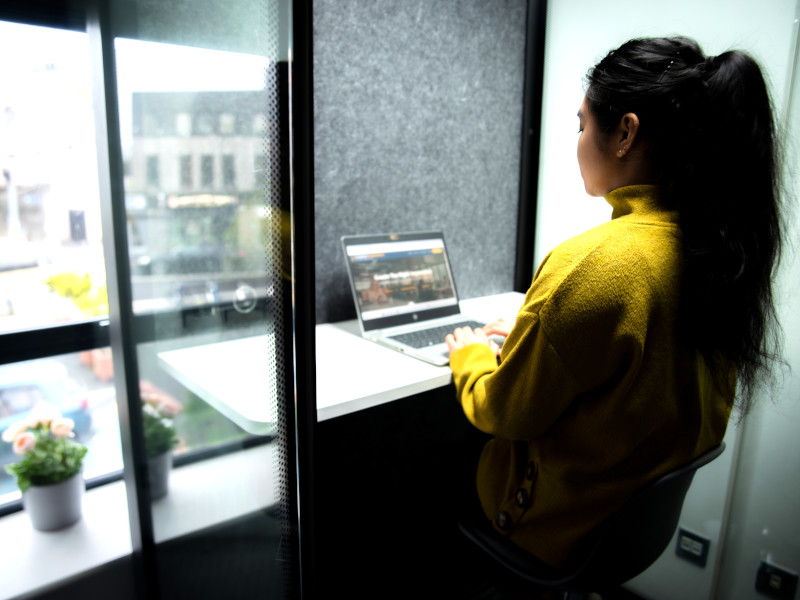 woman in yellow top working on her laptop